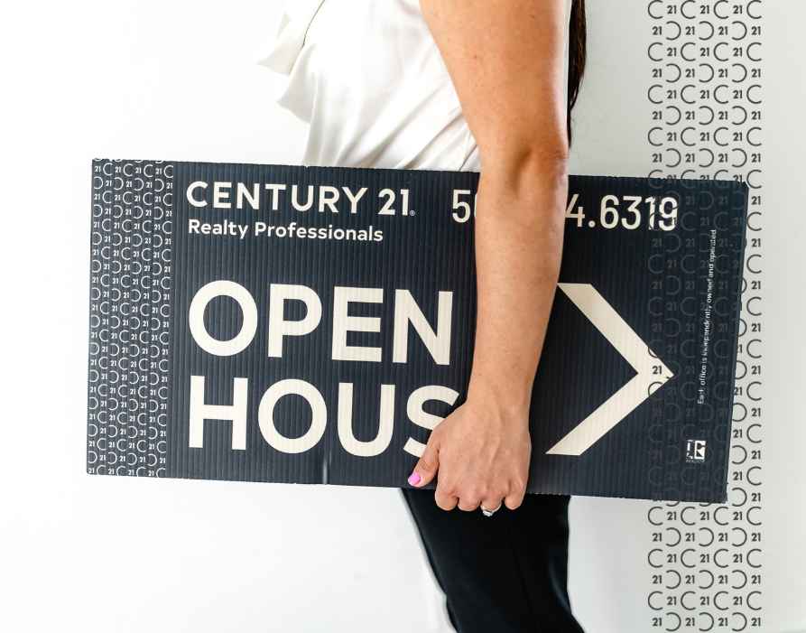 Century 21 real estate agent holding a Open House sign